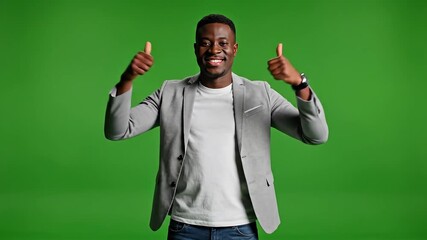 Enthusiastic African American Man Celebrates Success with Thumbs Up on Green Screen A Confident Young Professional in a Blazer Expressing Joy and Achievement in Studio.