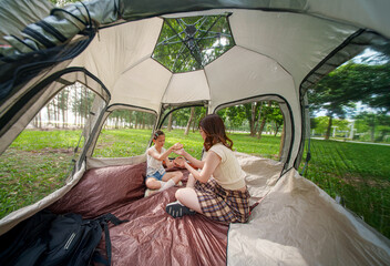 Mother and daughter practicing yoga together in a sunlit fitness studio