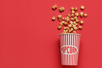 Bucket with tasty popcorn on red background