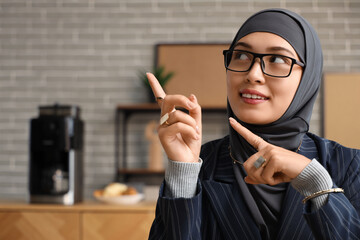 Muslim businesswoman pointing at something in office, closeup
