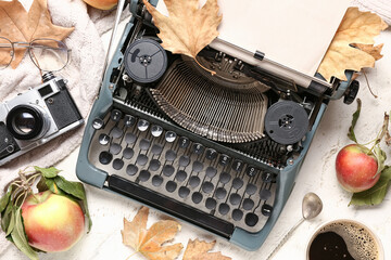 Vintage typewriter, apples, photo camera and autumn leaves on white background