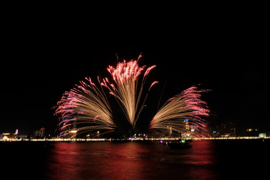 Spectacular colorful fireworks at Pattaya International Fireworks Festival 2025 viewed from a raft in the middle of Pattaya ocean. Vibrant reflections light up the dark ocean in Pattaya Bay, Thailand. - Powered by Adobe