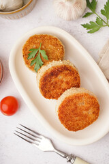 Plate of tasty meat cutlets on white background