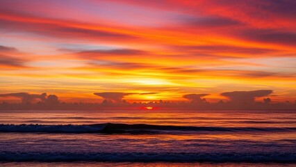 Obraz premium Vibrant tropical seascape at sunset, featuring an intensely colorful sky ablaze with fiery orange, red, and purple hues, reflecting majestically over the tranquil ocean waves