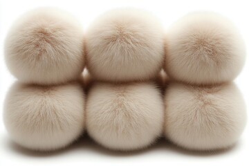 Six fluffy beige pom-poms are stacked on a white background, soft texture. Use it to illustrate winter fashion, crafting, or soft, cozy textures.