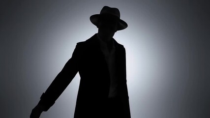Silhouette Man In Hat And Suit Standing Against Dramatic Spotlight Lighting In Studio Black And White