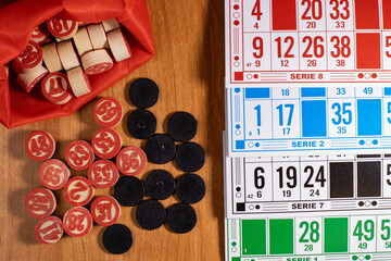 Exciting game of bingo with colorful cards and wooden pieces on a wooden table during a friendly gathering