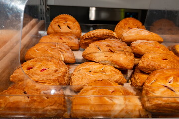 Freshly baked pastries displayed on a wooden shelf in a cozy bakery showcasing various flavors and textures during morning hours