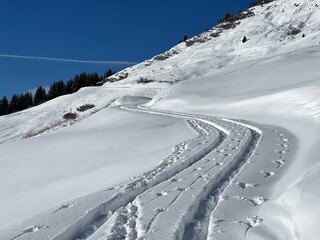 Wonderful winter hiking trails and traces in the fresh alpine snow cover of the Swiss Alps and over...