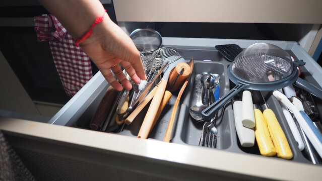 Organizing kitchen utensils in a cluttered drawer