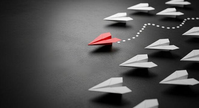Stand out from the crowd with unique ideas and inspired leadership, showing a red paper airplane leading white ones on a new strategic path