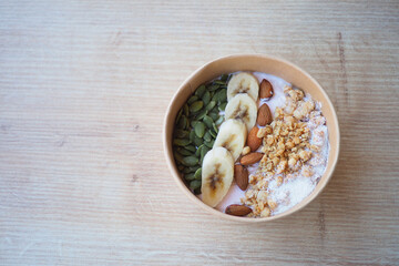 Delicious yogurt bowl topped with banana, nuts, and seeds