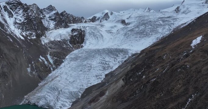 Beautiful high altitude hanging glacier and snow capped mountain with lake in Tibet, China