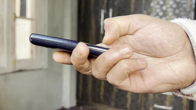 Closeup of a man writing SMS message on old push button mobile phone. A man writing a message and showing his old push button phone which were using in 2009 before.