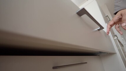 Person opening drawer in modern kitchen