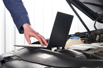 Car mechanic using computer in auto repair shop