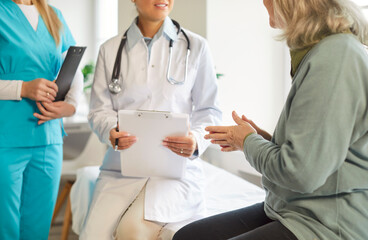 Senior patient interacting with a team of doctor and nurse during an appointment at a clinic or hospital. Healthcare, support, and the importance of medical consultations for elderly individuals.
