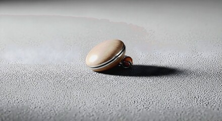 Elegant beige earring with silver accents casting a sharp shadow