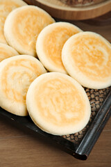 Handmade Chinese Steamed Buns with Golden Swirl Pattern on Bamboo Steamer