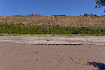 A muddy river in a canyon in the mountains.
