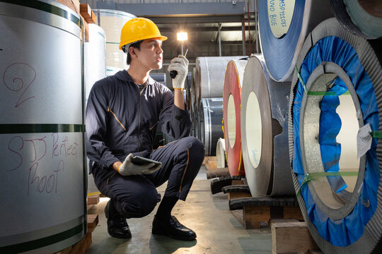Female worker inspecting sheet metal with tablet