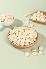 Peeled Sliced Almonds in Wooden Bowls on Green Background - Healthy Nuts for Cooking and Baking