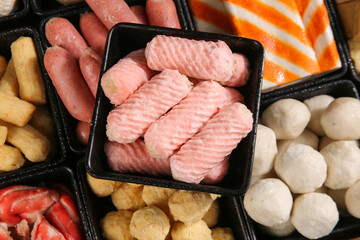 Hot pot ingredients variety with beef slices fish balls and sausages in compartments for Asian cooking