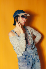 Smiling woman talking on the phone against orange background