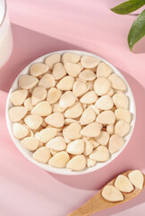 Peeled Sliced Sweet Almonds in White Bowl on Pink Background with Natural Styling