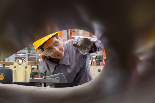 Female worker inspecting sheet metal with tablet