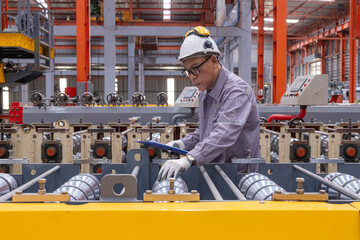 Engineers Overseeing Metal Sheet Production in Factory