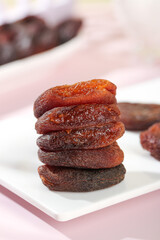 Dried Candied Apricots from Xinjiang China Stacked on White Plate - Traditional Preserved Fruit Snack