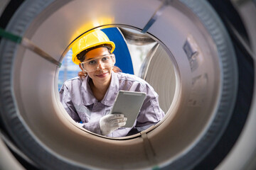 Female engineers inspecting metal sheet production line