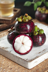 Fresh Mangosteen Tropical Fruit from Thailand on Rustic Wooden Board