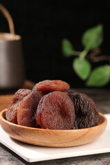 Xinjiang Dried Apricots in Wooden Bowl - Healthy Candied Fruit Snack on Dark Background