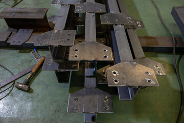 Metal beams with drilled connection plates in workshop