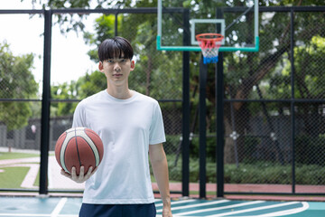 Young Man Holding Basketball on Court