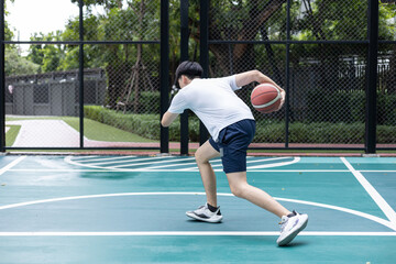Obraz premium Focused Basketball Player Dribbling on Court