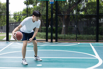 Obraz premium Focused Basketball Player Dribbling on Court