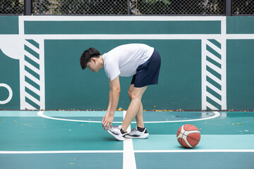 Young Athlete Stretching on Outdoor Basketball Court