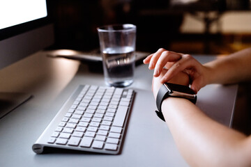Unrecognizable businesswoman in her office with smartwatch.
