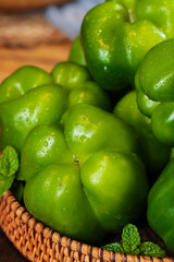 Fresh Green Bell Peppers in Wicker Basket with Water Droplets