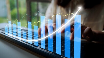 A focused individual types on a keyboard while digital graphs show business growth metrics and trends, highlighting the impact of data analysis on strategic decisions. Copula