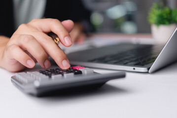 Accountant hand using calculator holding pen computing financial tax office desk laptop. Business male analyzing budget investment cost. Corporate finance economy accounting money concept.