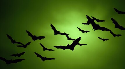 Silhouette of flying bats against a green background halloween concept