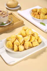 Crispy Golden Potato Snacks on Wooden Table with Coffee and Fresh Potatoes