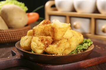Crispy Roasted Potato Wedges with Herbs in Wooden Bowl on Rustic Kitchen Table