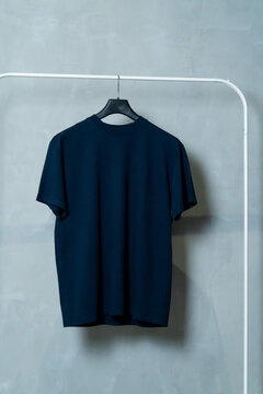 basic colored T-shirts on a minimalist clothes rack	