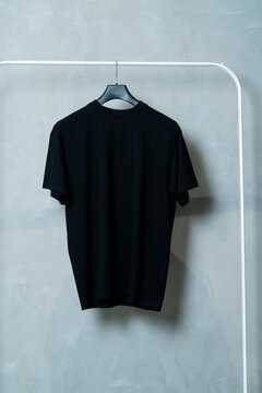 basic colored T-shirts on a minimalist clothes rack	