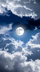 Dramatic full moon shining brightly through puffy clouds in a deep blue nighttime sky